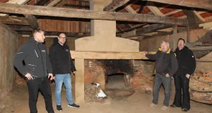 Der alte Backofen soll wieder brennen (von links): Die Handwerker Jan Schleicher und Tino Niess von Brawa Nord, Eigentümer Achim Peters und Zimmermeister Marco Matthies freuen sich über die gelungene Sanierung des alten Backhauses. Foto: Landkreis Harburg